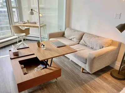 a living room with a couch and a table with a laptop at 25 Days Minimum - Luxury and Modern Downtown Apartment - Do not send request for less than 21 days in Vancouver