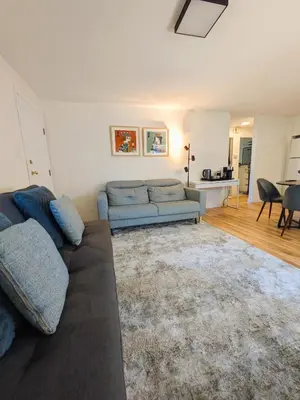 a living room with a couch and a table at Private room in Chic Main St suite in Vancouver