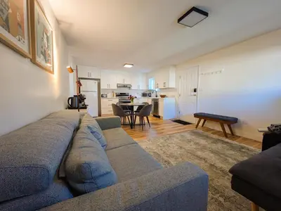 a living room with a blue couch and a kitchen at Private room in Chic Main St suite in Vancouver