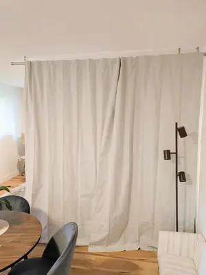 a white curtain in a living room with a table and chairs at Private room in Chic Main St suite in Vancouver