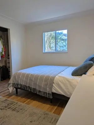 a bedroom with a bed and a window at 2 bedroom suite close to Main and Skytrain in Vancouver