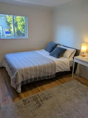 a bedroom with a bed and a window at 2 bedroom suite close to Main and Skytrain in Vancouver