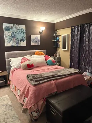 a bedroom with a bed with a pink blanket and pillows at Oasis in Surrey