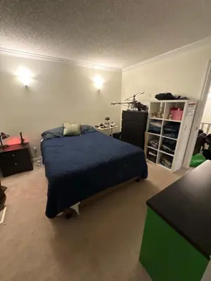 a bedroom with a bed with a blue comforter at Oasis in Surrey