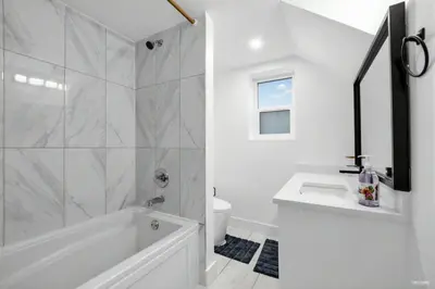 a white bathroom with a tub and a sink at Shanaz house in Vancouver