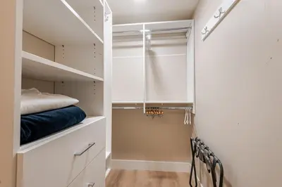 a walk in closet with white cabinets and blue sheets at Modern Bright Suite Self Check-In in North Vancouver