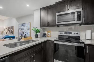 a kitchen with a sink and a microwave at Herron Rise Luxury 1 Bedroom Basement Suite in Calgary