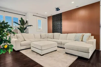a living room with a white couch and two chairs at Luxury Haven | Pool | Hot Tub & Sauna |Outdoor BBQ in Calgary
