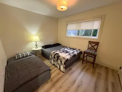two beds in a room with a window at Vancouver Downtown Cozy Room - 5-Min Walk to BC Place & Skytrain - Free Parking in Vancouver