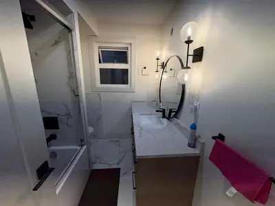 a white bathroom with a sink and a shower at Vancouver Downtown Cozy Room - 5-Min Walk to BC Place & Skytrain - Free Parking in Vancouver