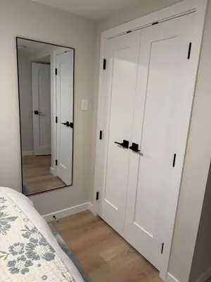 a bedroom with white cabinets and a mirror at Rosie Cozy Retreat in Victoria