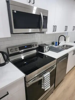 a kitchen with a stove and a microwave at Mayfair Suite in Airdrie