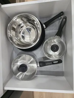 two pots and pans sitting in a drawer at Mayfair Suite in Airdrie