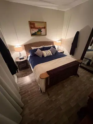 a bedroom with a large bed with two lamps on two tables at Spacious 4-Season Cabin with Lakefront Views in Silver Sands in Seba Beach