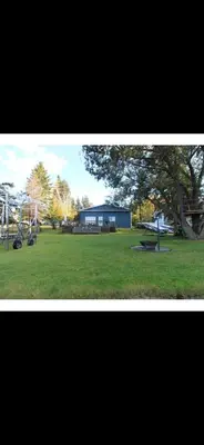 a view of a park with a blue building in the background at Spacious 4-Season Cabin with Lakefront Views in Silver Sands in Seba Beach
