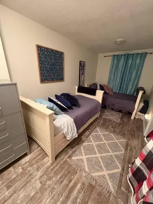 a bedroom with a bed and a dresser in it at Spacious 4-Season Cabin with Lakefront Views in Silver Sands in Seba Beach