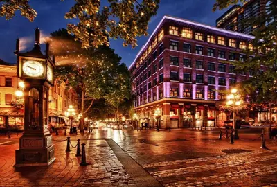 a clock tower on a city street at night at Luxury High Rise at Gastown Near BC Place in Vancouver