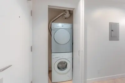 a washer and dryer in a white room at Luxury High Rise at Gastown Near BC Place in Vancouver