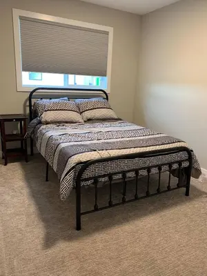 a bed sitting in a room with a window at New townhouse in Red Deer -Family retreat in Red Deer