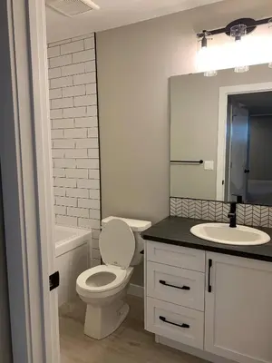 a bathroom with a toilet and a sink and a mirror at New townhouse in Red Deer -Family retreat in Red Deer