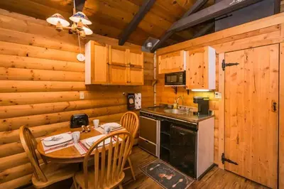 a kitchen with a table and a sink in a cabin at The White Tail Cabin - Bear Creek Cabins in Winfield