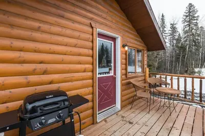 a porch of a cabin with a grill and a table and chairs at The Mustang Cabin - Bear Creek Cabins in Winfield