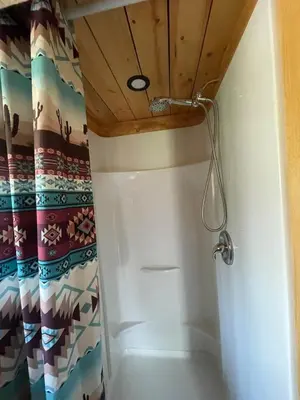 a bathroom with a shower with a wooden ceiling at The Ram cabin - Bear Creek cabins in Winfield