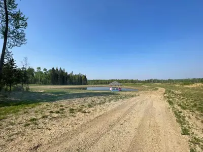 a dirt road with a small building in the middle of a field at The Lynx cabin - Bear Creek Cabins in Winfield