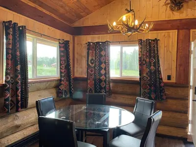 a dining room with a table and chairs and windows at The Deerview cabin - a part of Bear Creek Cabins in Winfield