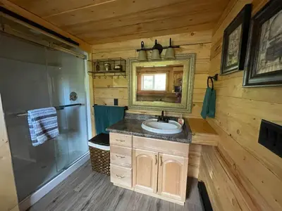 a bathroom with a sink and a shower and a mirror at The Deerview cabin - a part of Bear Creek Cabins in Winfield