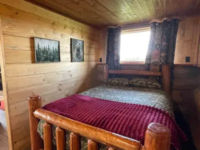 a bedroom in a log cabin with a bed in it at The Deerview cabin - a part of Bear Creek Cabins in Winfield