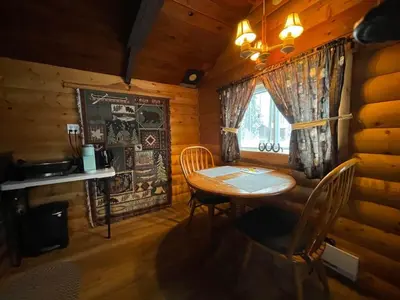 a dining room with a table and chairs in a cabin at The Sheep Camp cabin- Bear Creek Cabins in Winfield