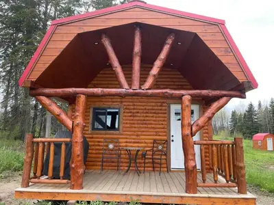a log cabin with a table in front of it at The Cowboy cabin - Bear Creek Cabins in Winfield