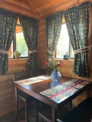 a dining room with a table and two windows at The Moose cabin - Bear Creek Cabins in Winfield