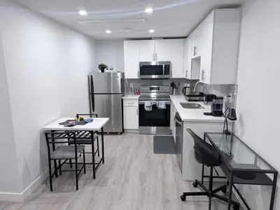 a kitchen with white appliances and a table and chairs at Charming Family-Friendly House Rental in Edmonton in Edmonton
