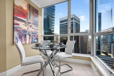 a dining room with a table and chairs in front of a window at Stunning 2BR Apartment with Best Mountain View Downtown in Vancouver