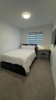 a bedroom with a bed and a desk and a window at 3BR Family House in NE Edmonton in Edmonton