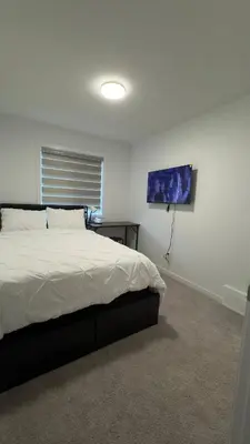 a bedroom with a bed in a white room at 3BR Family House in NE Edmonton in Edmonton