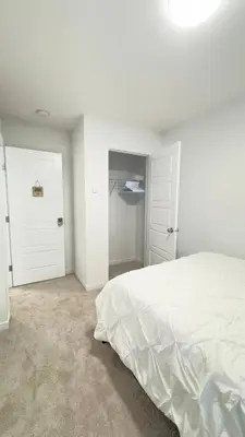 a white bedroom with a bed and a closet at 3BR Family House in NE Edmonton in Edmonton