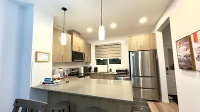 a kitchen with a counter and a refrigerator at 3BR Family House in NE Edmonton in Edmonton