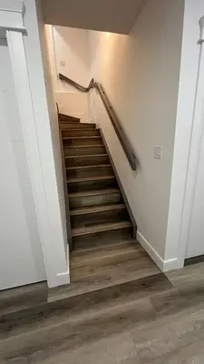 a staircase in a house with wooden floors at Cozy 2 bedroom suite in Edmonton
