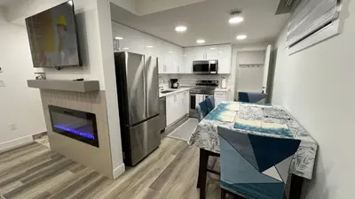 a small kitchen with a table and a refrigerator at Cozy 2 bedroom suite in Edmonton