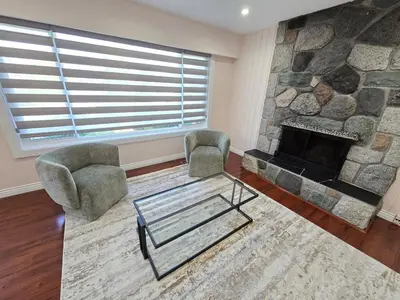 a living room with two chairs and a stone fireplace at 3 BR Lux home with AC in a central location in Delta
