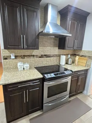 a kitchen with wooden cabinets and a stove top oven at 3 BR Lux home with AC in a central location in Delta