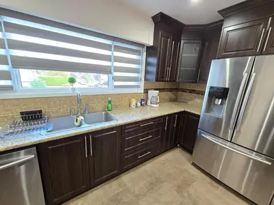 a kitchen with wooden cabinets and a stainless steel refrigerator at 3 BR Lux home with AC in a central location in Delta