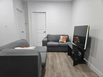 a living room with a couch and a mirror at Your home away from home comfortable, and calm, in Edmonton