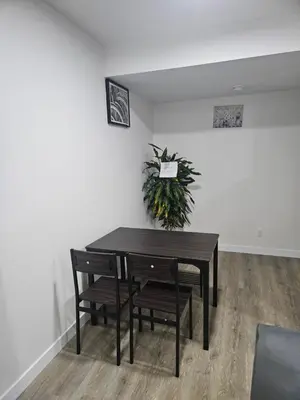a table and chairs in a room with a plant at Your home away from home comfortable, and calm, in Edmonton