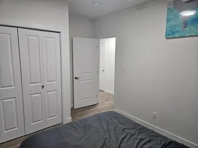 a bedroom with a bed and two white doors at Your home away from home comfortable, and calm, in Edmonton