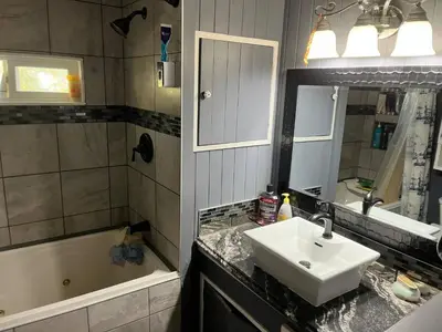 a bathroom with a sink and a bath tub at Rustic suite in small town Alberta Canada in Penhold