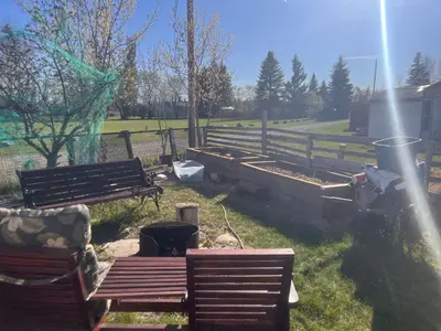 a group of benches in a park with a fence at Rustic suite in small town Alberta Canada in Penhold